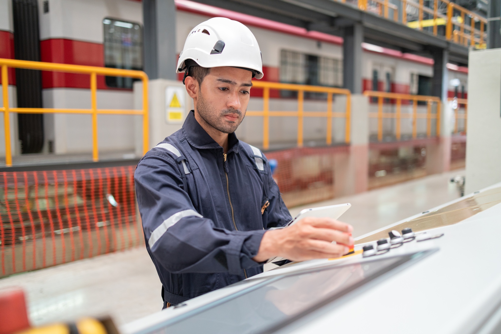 Engineer uses equipment to survey the level of railroad tracks in a maintenance plant.