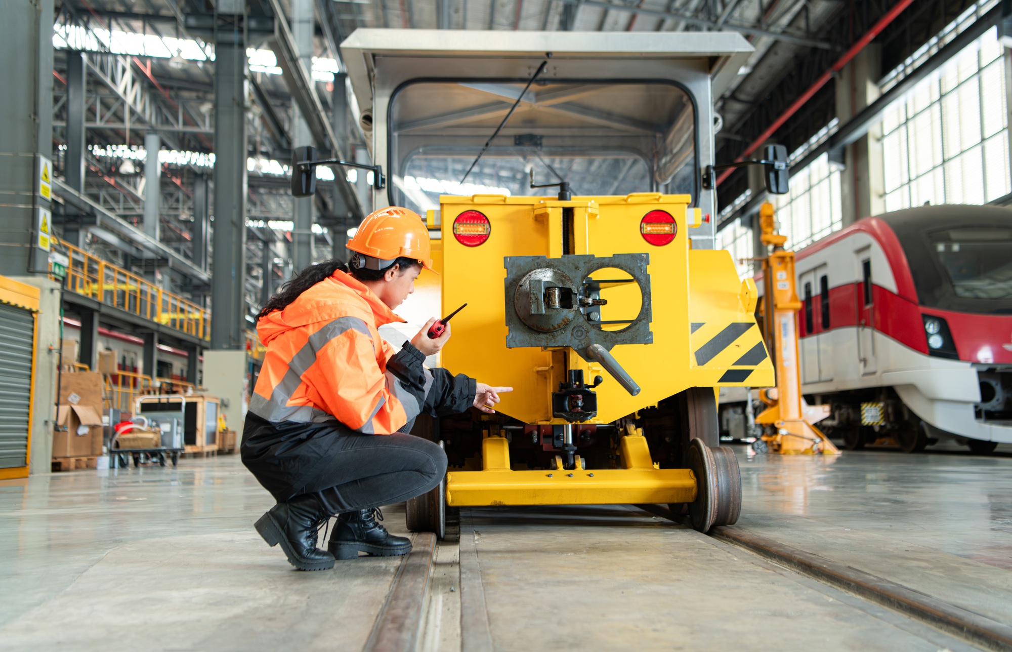 Female engineer working in electric train repair shop, Inspecting small grinding the railroad track