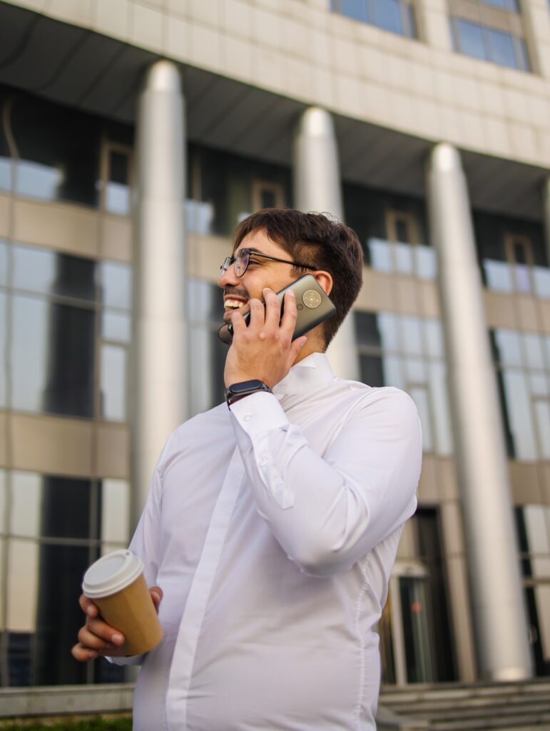 Pleased european businessman talking on mobile phone. Businessman Outside Office On Mobile Phone